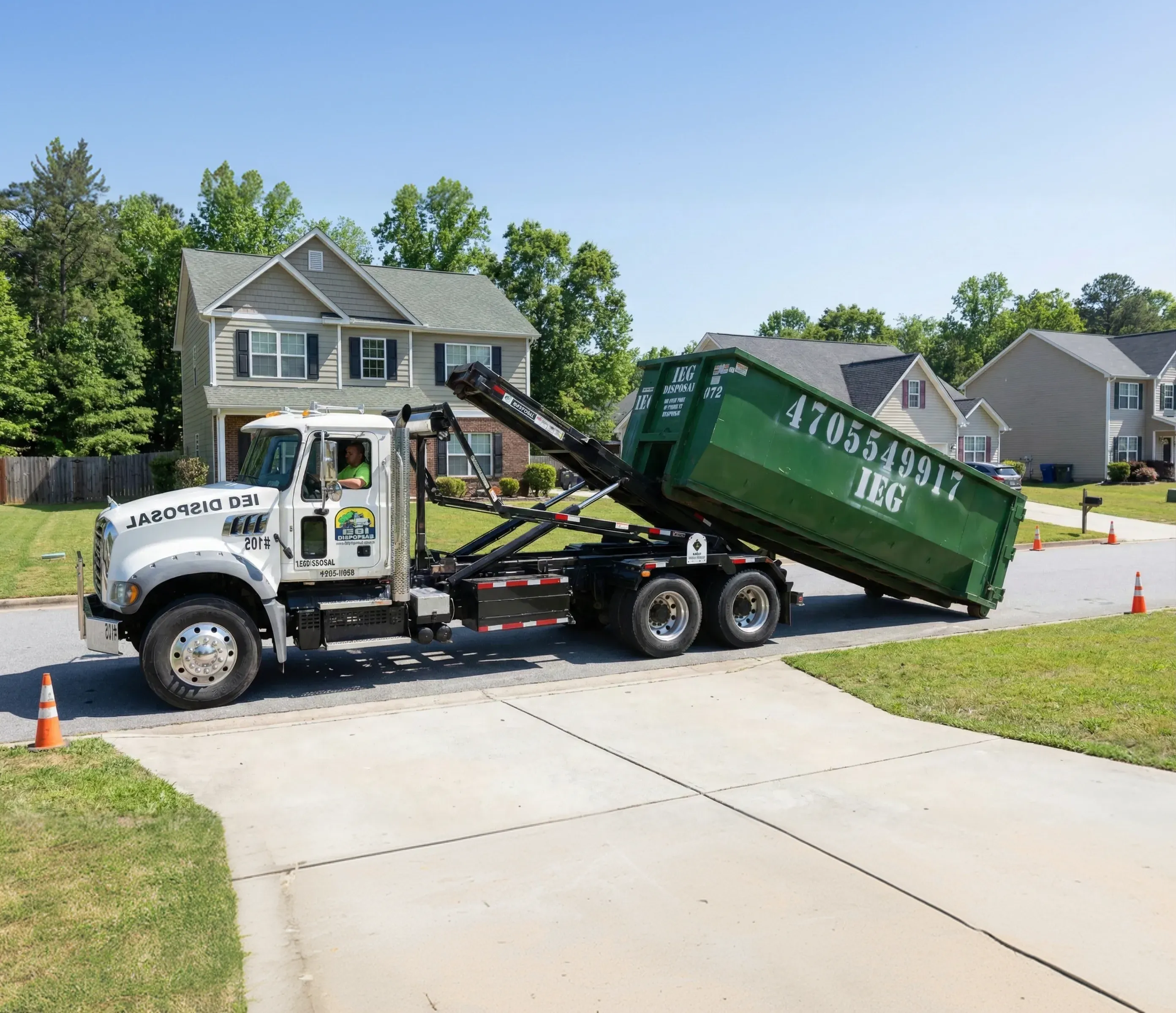 A dumpsters being dropped off in front of a house.